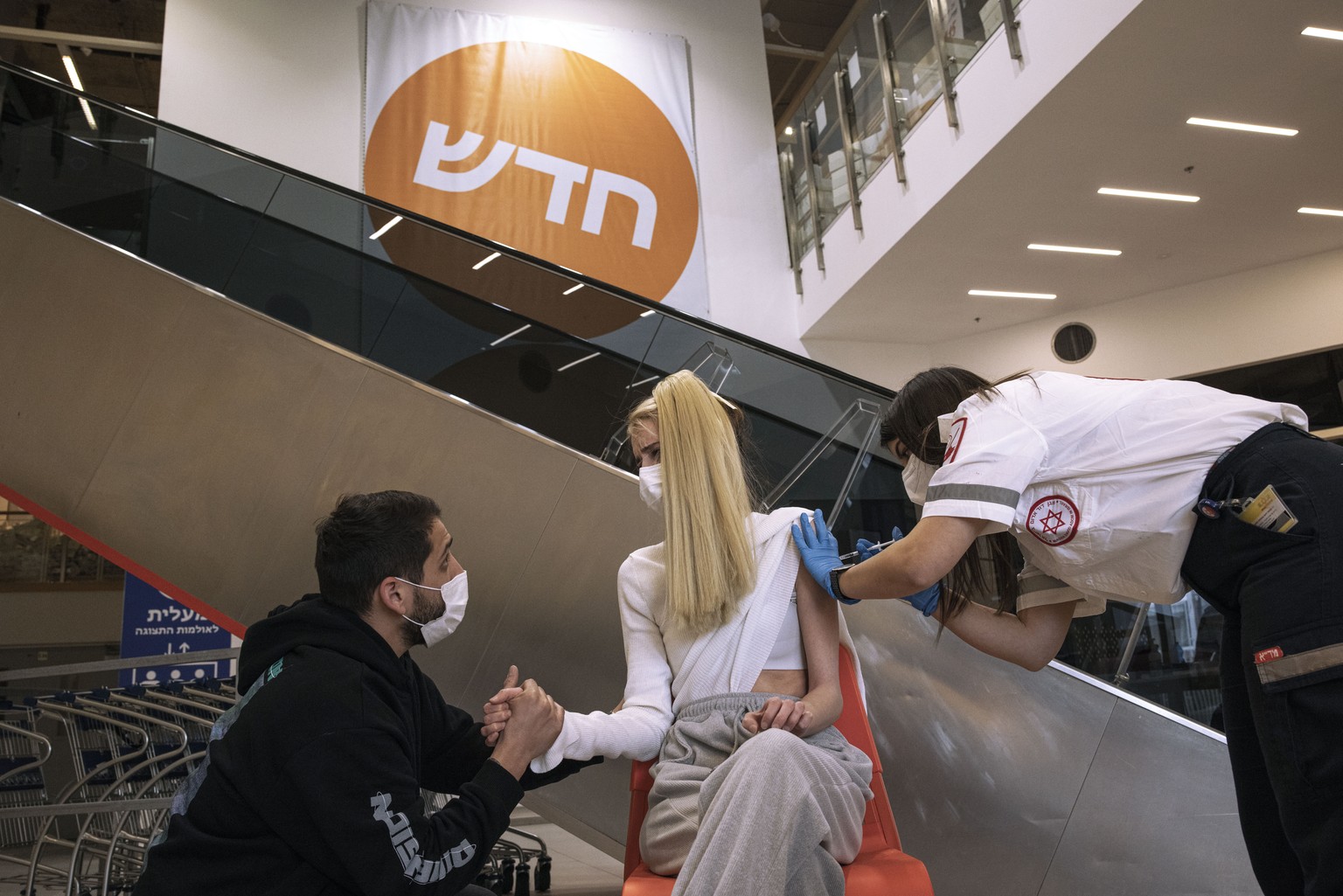 An Israeli paramedic from Magen David Adom medical services, administers a dose of the Pfizer-BioNtech COVID-19 vaccine to a woman at an Ikea store in Rishon Lezion, Israel, Monday, Feb. 22, 2021. Ike ...