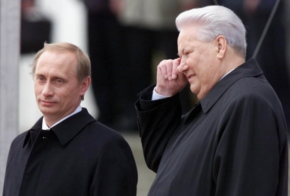 Russian President Vladimir Putin, left, and former President Boris Yeltsin watch Kremlin guards marching in Moscow&#039;s Kremlin, May 7, 2000. In his first public criticism of the man he promoted to  ...