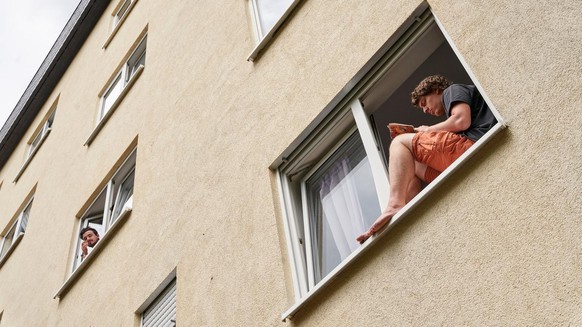 09.07.2020, Rheinland-Pfalz, Koblenz: Wouter liest auf der Fensterbank eines Studentenwohnheims. Drei Wohnheime mit insgesamt 188 Studierenden stehen aufgrund von Corona-Infektionen unter Quarant