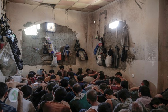 FILE - In this Tuesday, July 18, 2017 file photo, Suspected Islamic State members sit inside a small room in a prison south of Mosul, Iraq. A leading international human rights organization is critici ...