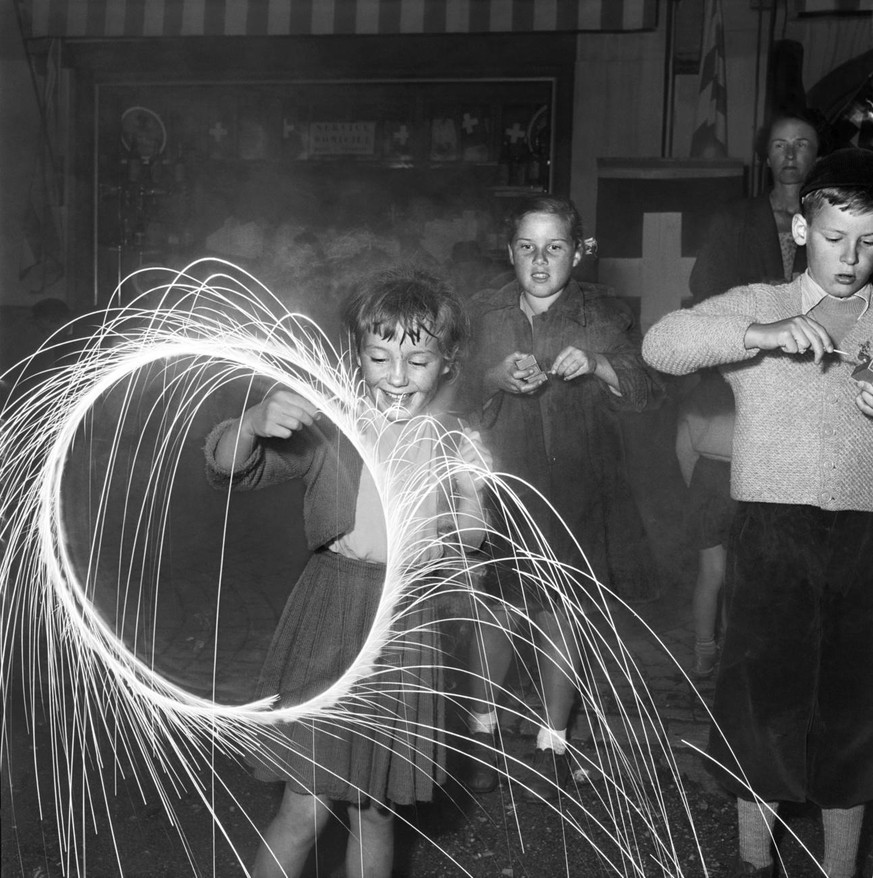 Children play with sparklers during the Swiss National Day celebrations in Le Sepey, canton of Valais, Switzerland, on August 1, 1953. (KEYSTONE/PHOTOPRESS-ARCHIV/Bar.)

Kinder spielen an der Bundesfe ...