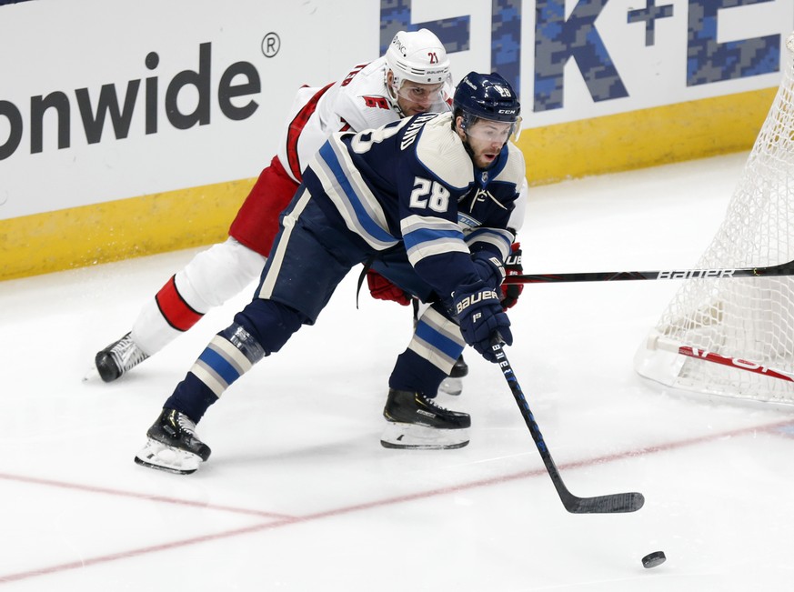 Columbus Blue Jackets forward Oliver Bjorkstrand, right, controls the puck in front of Carolina Hurricanes forward Nino Niederreiter during the first period of an NHL hockey game in Columbus, Ohio, Su ...