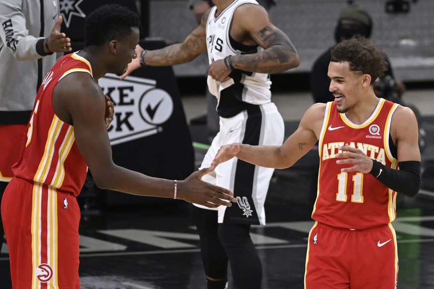 Atlanta Hawks&#039; Trae Young (11) and Clint Capela celebrate the team&#039;s double-overtime victory against the San Antonio Spurs in an NBA basketball game Thursday, April 1, 2021, in San Antonio.  ...