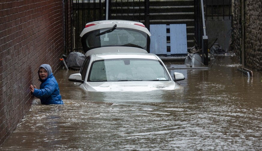 epa08222024 A boy wades towards a flooded alleyway in Pontypridd, South Wales, Britain, 16 February 2020, after Storm Dennis hit the area last night bringing torrential rains, floods and landslides. E ...