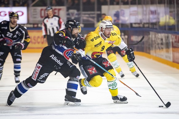 Le defenseur fribourgeois Marc Abplanalp, gauche, lutte pour le puck avec le joueur bernois Jan Mursak, droite, lors de la rencontre du championnat suisse de hockey sur glace de National League entre  ...