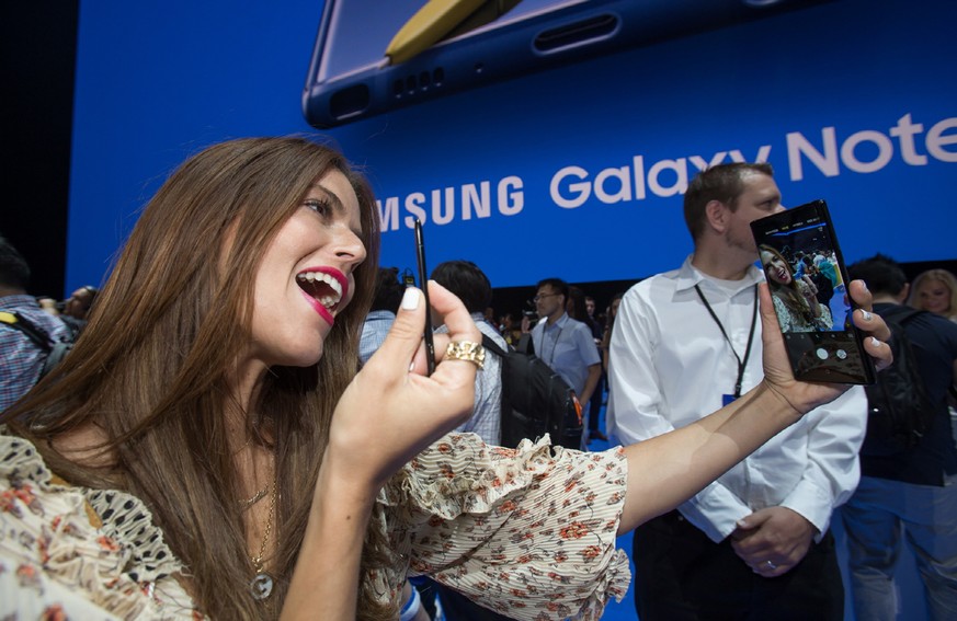 epa06939621 A handout photo made available by Samsung Electronics Co., Ltd shows a woman taking a selfie with Samsung Electronics Co.&#039;s new Galaxy Note 9 smartphone during a rollout event at Barc ...