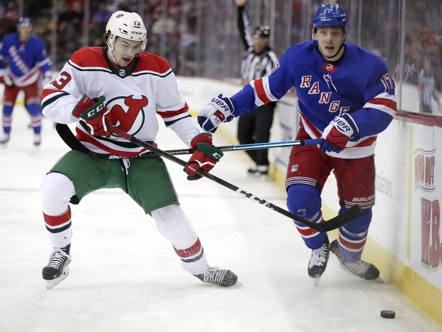 New Jersey Devils center Nico Hischier (13), of Switzerland, and New York Rangers right wing Jesper Fast (17), of Sweden, compete for the puck during the first period of an NHL hockey game, Thursday,  ...