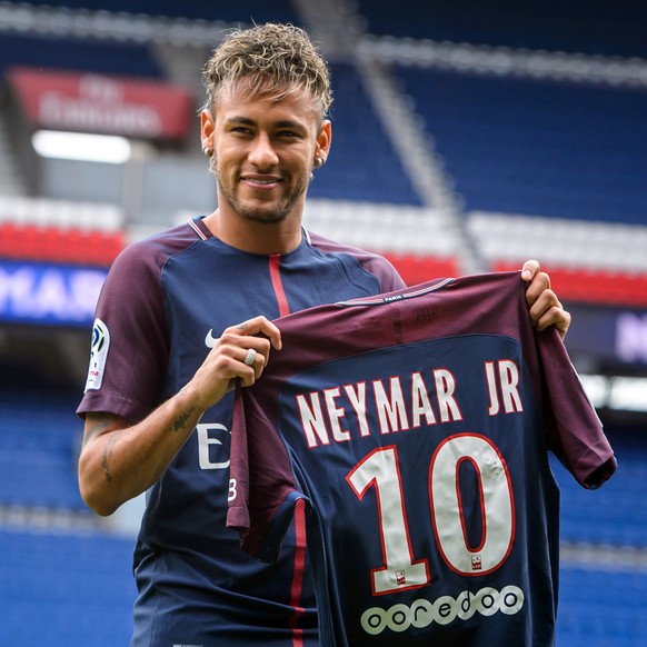 epa06124293 Brazilian striker Neymar Jr. poses for photographs with his new PSG jersey after a press conference at the Parc des Princes stadium in Paris, France, 04 August 2017. Neymar Jr is presented ...