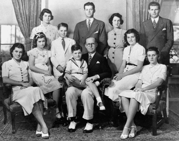 Joseph P. Kennedy and his wife Rosemary Kennedy pose with their nine children for this picture in 1938 at Bronxville, N.Y. From left are, seated: Eunice, Jean, Edward (on lap of his father), Patricia, ...