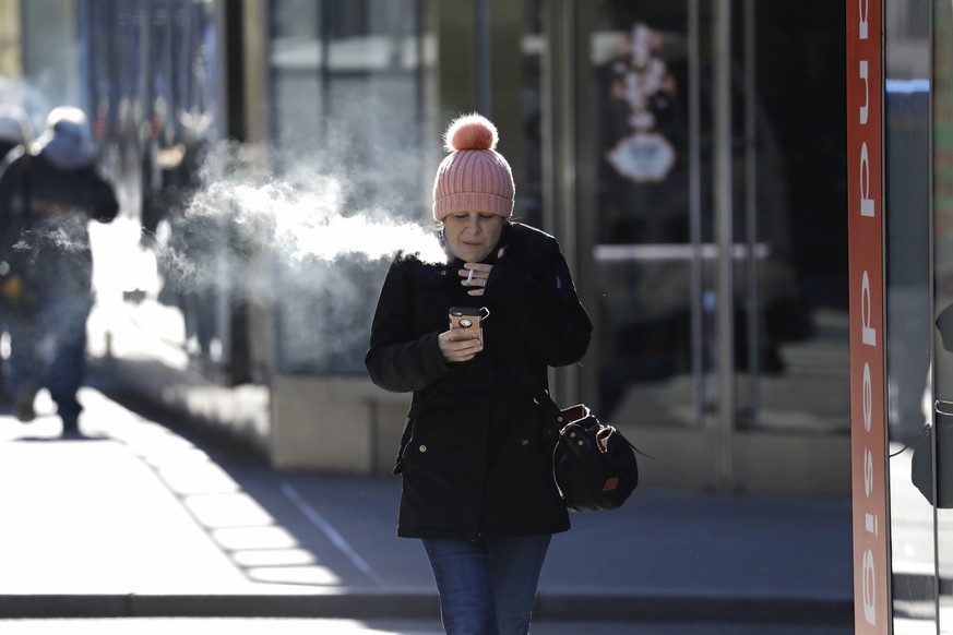 epa07307293 A woman smokes a cigarette in extremely cold weather that is blanketing the Northeast region in New York, New York, USA, 21 January 2019. Temperatures today dipped to the lowest levels in  ...