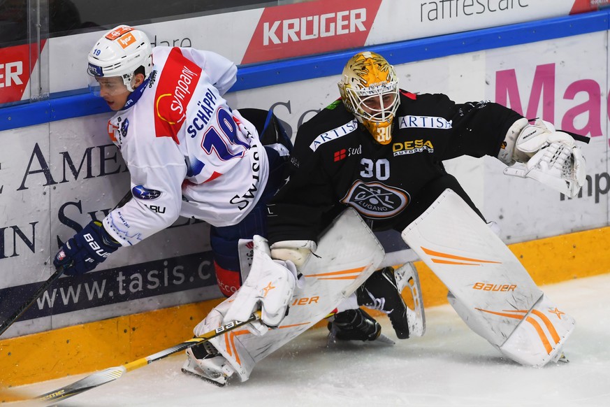 Zurich&#039;s player Reto Schaeppi, left, fight for the puck with Lugano&#039;s goalkeeper Elvis Merzlikins, right, during the preliminary round game of National League Swiss Championship 2018/19 betw ...