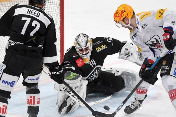 From left, Lugano&#039;s player Tim Heed, Lugano&#039;s goalkeeper Niklas Schlegel and Fribourg&#039;s player Chris DiDomenico, during a National League regular season game of the Swiss ice hockey cha ...