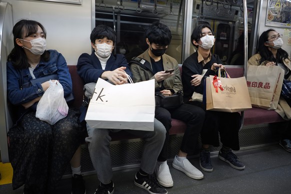 epa08326199 Commuters wearing masks ride in a subway in Tokyo, Japan, 27 March 2020. Tokyo Governor Koike asked for people to stay home on the 28-29 March weekend amid a sharp increase in the number o ...