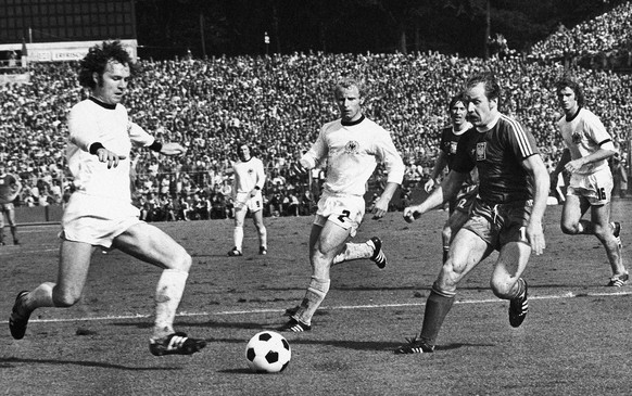 West Germany&#039;s captain Franz Beckenbauer, left, kicks the ball away from advancing Polish player Robert Gadocha during the Football World Cup second round match between West Germany and Poland at ...