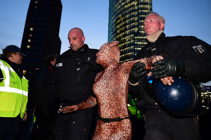 epa07904172 Police officers carry away an activist for the global environment movement Extinction Rebellion XR as they blocked the &#039;Potsdamer Platz&#039; crossroads in Berlin, Germany, 07 October ...
