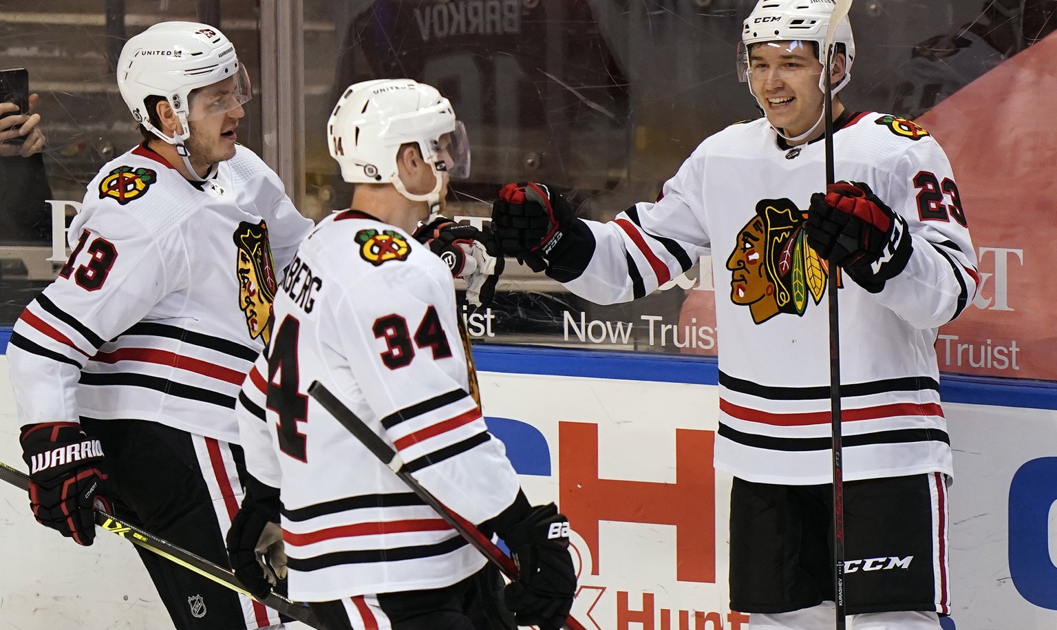 Chicago Blackhawks center Philipp Kurashev (23) is congratulated by teammates Mattias Janmark (13) and Carl Soderberg (34) after he scored a goal during the second period of an NHL hockey game against ...