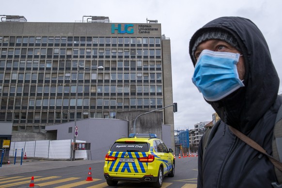 A person wearing protective face mask as a precaution against the spread of the coronavirus COVID-19 arrives to the Geneva University Hospitals (HUG), in Geneva, Switzerland, Monday, March 30, 2020. T ...