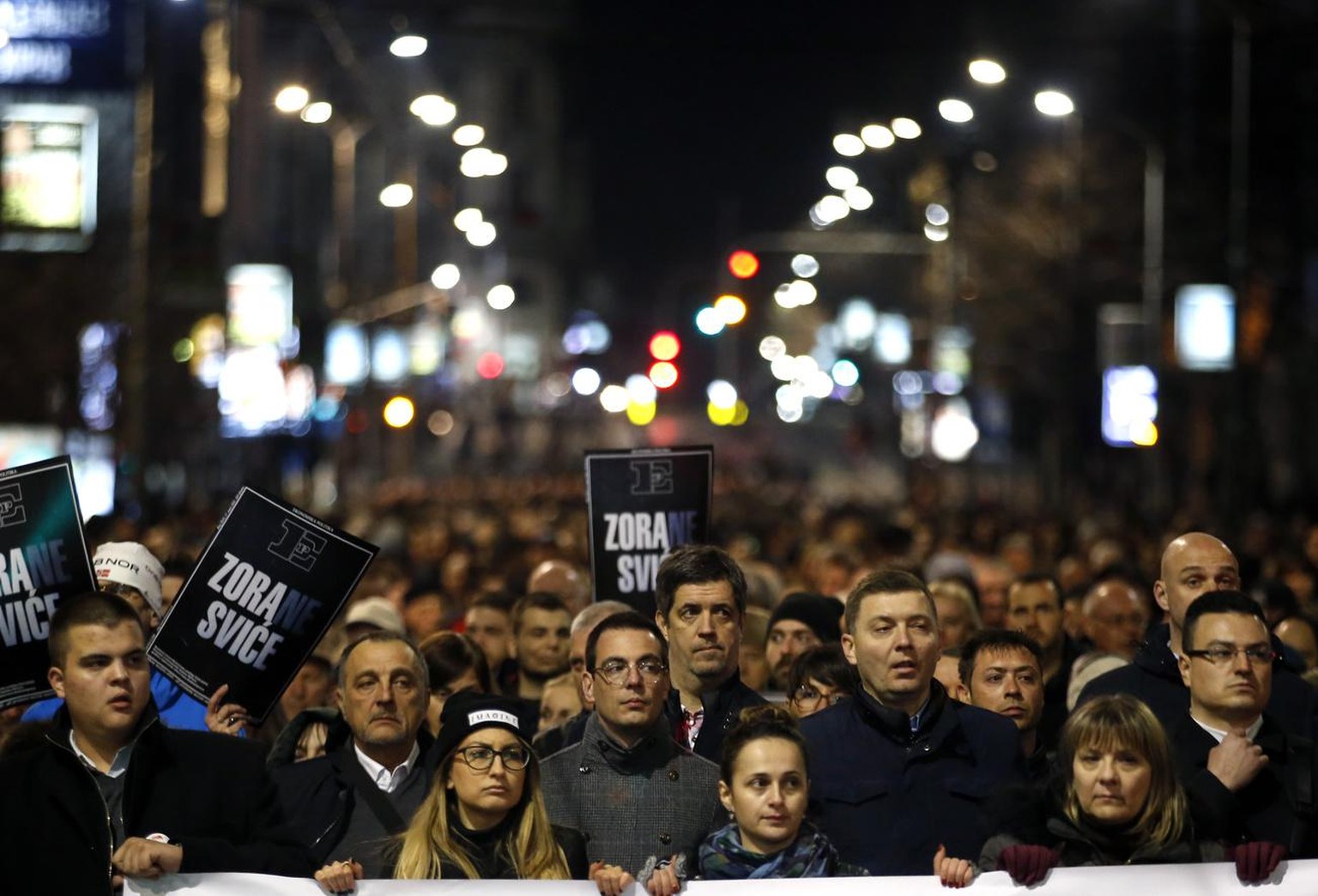 People march down a street toward a memorial service marking the 16th anniversary of the assassination of the first democratic prime minister Zoran Djindjic, in Belgrade, Serbia, Tuesday, March 12, 20 ...
