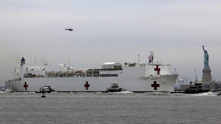 epa08332424 The USNS Comfort hospital ship sails into New York Harbor and approaches the Statue of Liberty in New York, New York, USA, 30 March 2020. The ship, which has a 1,000 bed hospital on board, ...