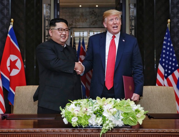 epa07346863 (FILE) - US President Donald J. Trump (R) and North Korean Chairmain Kim Jong-un (L) shake hands after signing a document during their historic DPRK-US summit, at the Capella Hotel on Sent ...