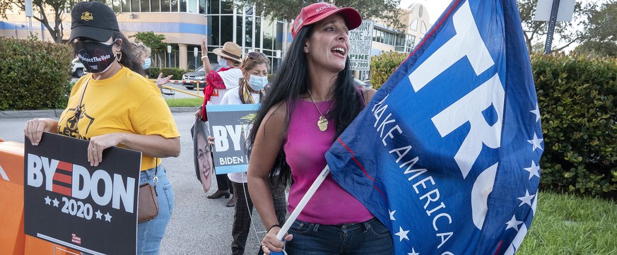 epa08797188 US President Donald Trump?s supporters and Democratic Candidate Joe Biden?s supporters cheer during Election Day in front of the Miami-Dade Elections Department in Miami, Florida, USA, 03  ...