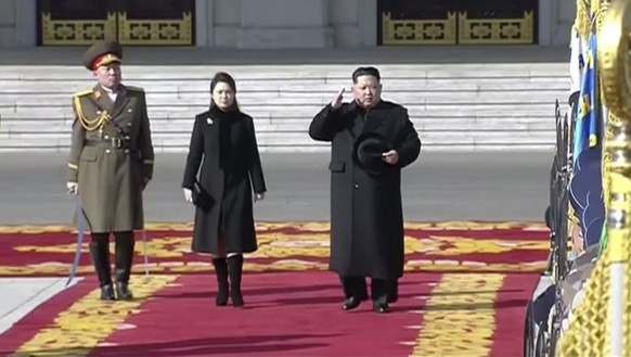 In this image made from video released by KRT on Feb. 8, 2018, North Korean leader Kim Jong Un, right, inspects honor guards, along with his wife Ri Sol Ju, center, during a military parade in Pyongya ...