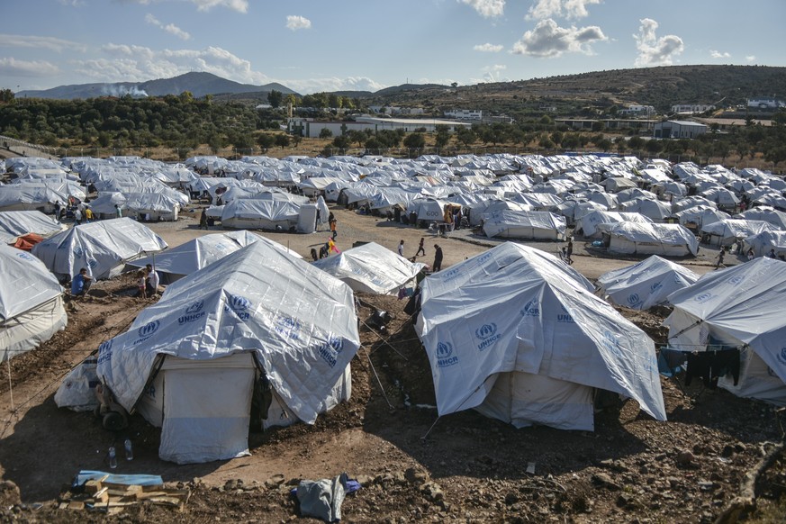 Migrants gather after a rainstorm at the Kara Tepe refugee camp, on the northeastern Aegean island of Lesbos, Greece, Wednesday, Oct. 14, 2020. Around 7,600 refugees and migrants have settled at the n ...