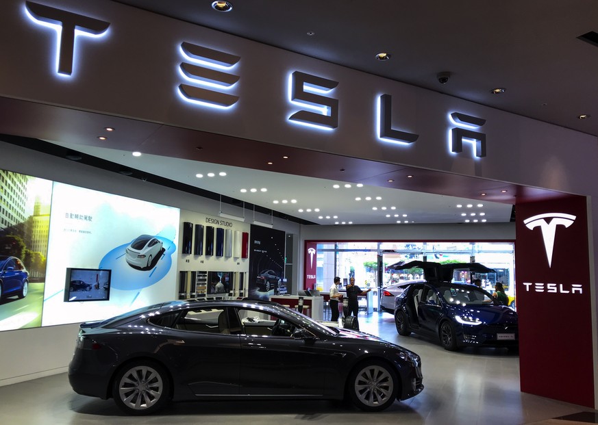 epa06976042 People view Tesla cars at a Tesla showroom center in Taipei, Taiwan, 27 August 2018. Tweets by Tesla CEO Elon Musk that he is considering taking the company private on 07 August 2018, may  ...
