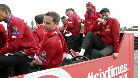 Liverpool manager Jurgen Klopp, right, rides an open top bus with team members during the Champions League Cup Winners Parade in Liverpool, England, Sunday June 2, 2019. Liverpool is champion of Europ ...