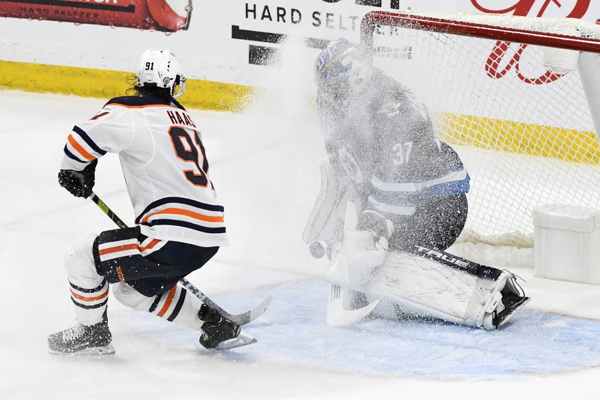 Winnipeg Jets goaltender Connor Hellebuyck (37) makes a save on Edmonton Oilers&#039; Gaetan Haas (91) during second overtime period of an NHL hockey Stanley Cup playoff game, Monday, May 24, 2021, in ...