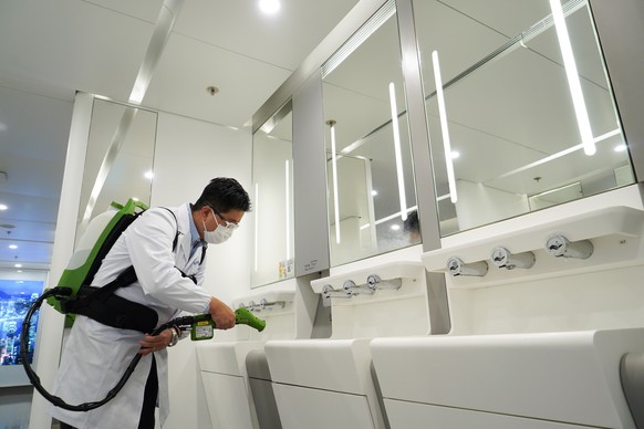 epa08387102 A handout photograph provided by Hong Kong International Airport shows a worker spraying disinfectant in a public toilet in Hong Kong International Airport in Hong Kong, China, 24 April 20 ...