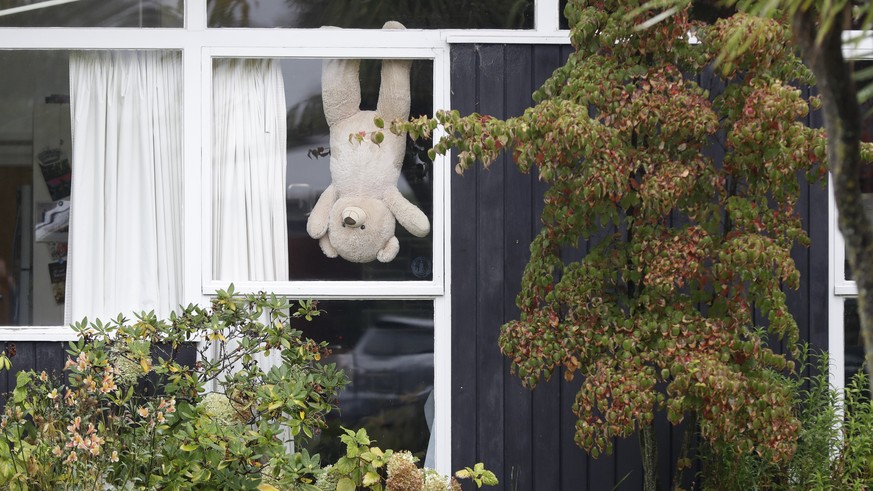 In this Monday, March 30, 2020, photo, a teddy bear hangs upside down in a window of a house in Christchurch, New Zealand. New Zealanders are embracing an international movement in which people are pl ...