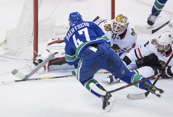 Vancouver Canucks&#039; Sven Baertschi (47), of Switzerland, is stopped by Chicago Blackhawks goalie Anton Forsberg, of Sweden, as Michal Kempny, right, of the Czech Republic, defends during the third ...