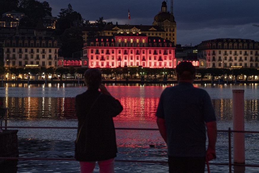 epa08502911 The Hotel Schweizerhof is pictured lit up in red during the action &#039;Night of light&#039; campaign, in Luzern, Switzerland, 22 June 2020, 22 June 2020. Monday evening numerous public m ...