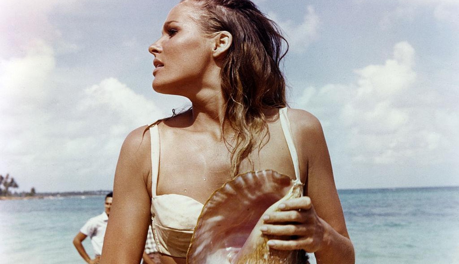 Ursula Andress, Swedish actress, wearing a white bikini and holding a conch shell in a publicity still issued for the film, &#039;Dr No&#039;, 1962. The James Bond film, directed by Terence Young (191 ...