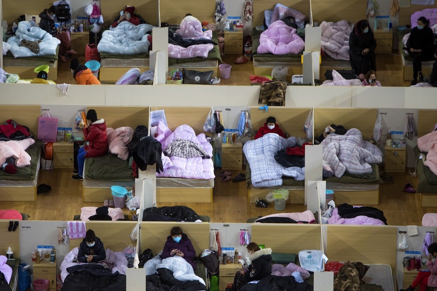 In this Monday, Feb. 17, 2020, photo released by Xinhua News Agency, patients infected with the coronavirus take rest at a temporary hospital converted from Wuhan Sports Center in Wuhan in central Chi ...