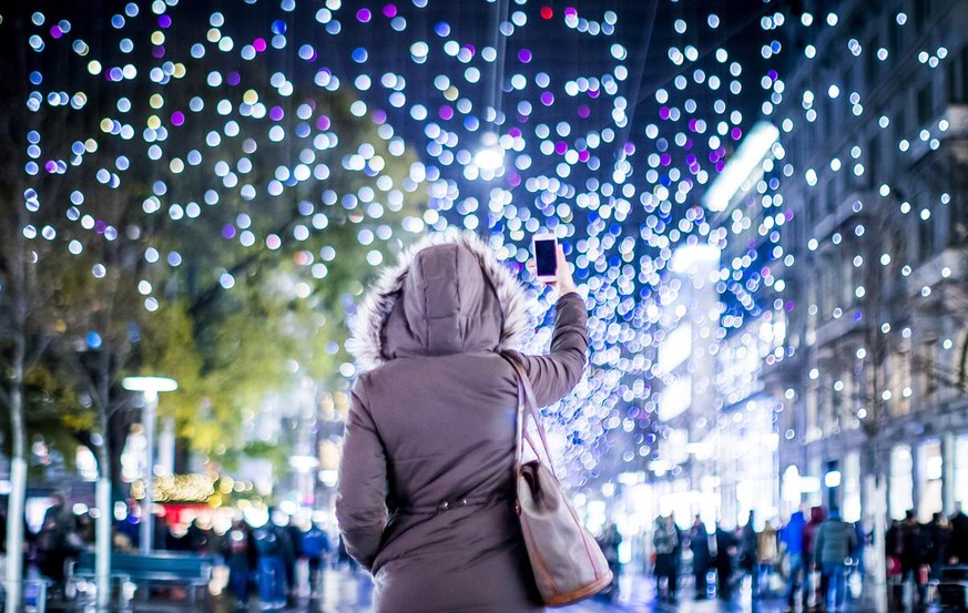 BILD DER WOCHE NATIONAL - Eine Passantin fotografiert die offizielle Weihnachtsbeleuchtung der Stadt Zuerich mit dem Namen &#039;Lucy&#039; an der Zuercher Bahnhofstrasse, am Donnerstag, 30. November  ...