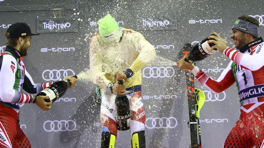 From left, second placed Austria&#039;s Marco Schwarz, first placed Switzerland&#039;s Daniel Yule and third placed Austria&#039;s Michael Matt celebrate on the podium with sparkling wine at the end o ...