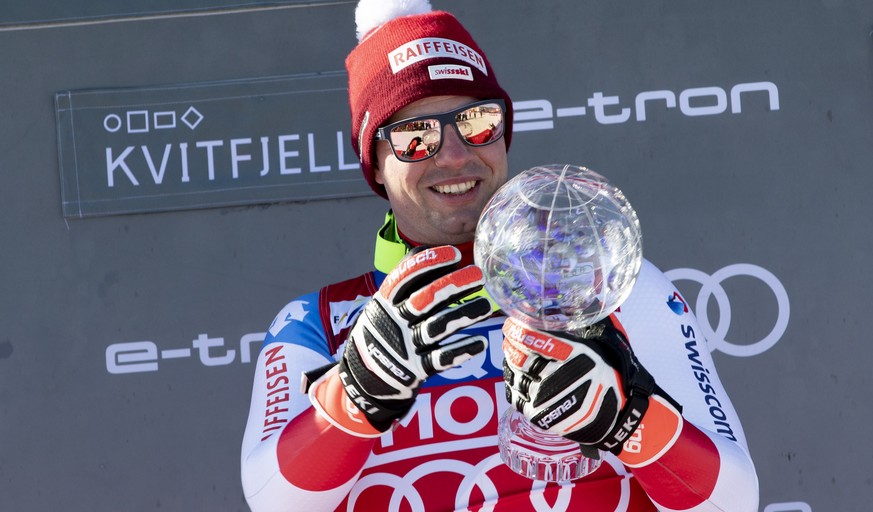 epa08276357 Overall winner of the downhill World Cup, Beat Feuz from Switzerland, celebrates with the trophy on the podium after the FIS Alpine Skiing World Cup Men&#039;s Downhill in Kvitfjell, Norwa ...