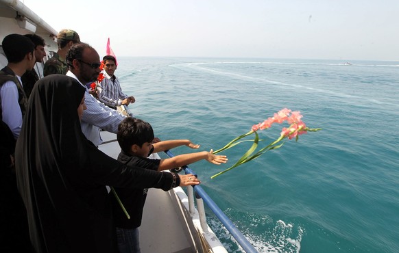 epa08118670 (FILE) - Relatives of Iranian passengers who were killed when a US warship shot down an Iranian airliner in 1988, throw flowers into the Persian gulf during a commemoration of the 24th ann ...