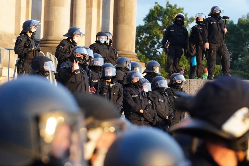 epa08634450 Policemen stand in front of the Reichstag building after demonstrators tried to climb the stairs after a protest against coronavirus pandemic regulations in Berlin, Germany, 29 August 2020 ...