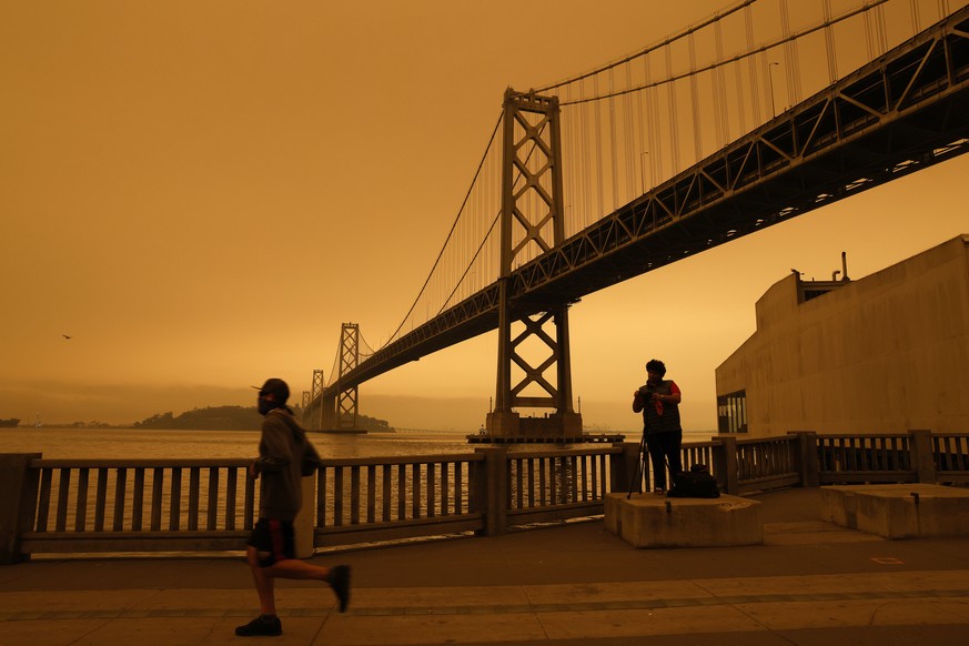 epa08760897 YEARENDER 2020 ..CLIMATE CHANGE ....A view of the San Francisco Bay Bridge under an orange overcast sky in the afternoon in San Francisco, California, USA, 09 September 2020. California wi ...