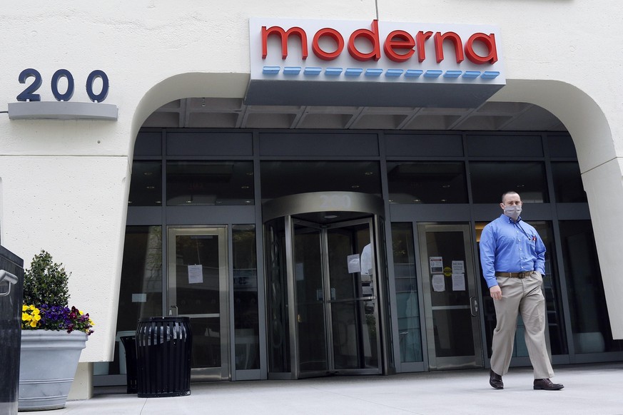 A man stands outside an entrance to a Moderna, Inc., building, Monday, May 18, 2020, in Cambridge, Mass. Moderna announced Monday that an experimental vaccine against the coronavirus showed encouragin ...