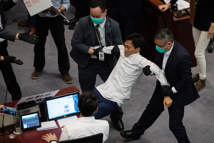 epa08409326 Pro-democracy lawmaker Eddie Chu Hoi-dick (C) is removed from a House Committee by security guards at the Legislative Council in Hong Kong, China, 08 May 2020. Several pro-democracy legisl ...