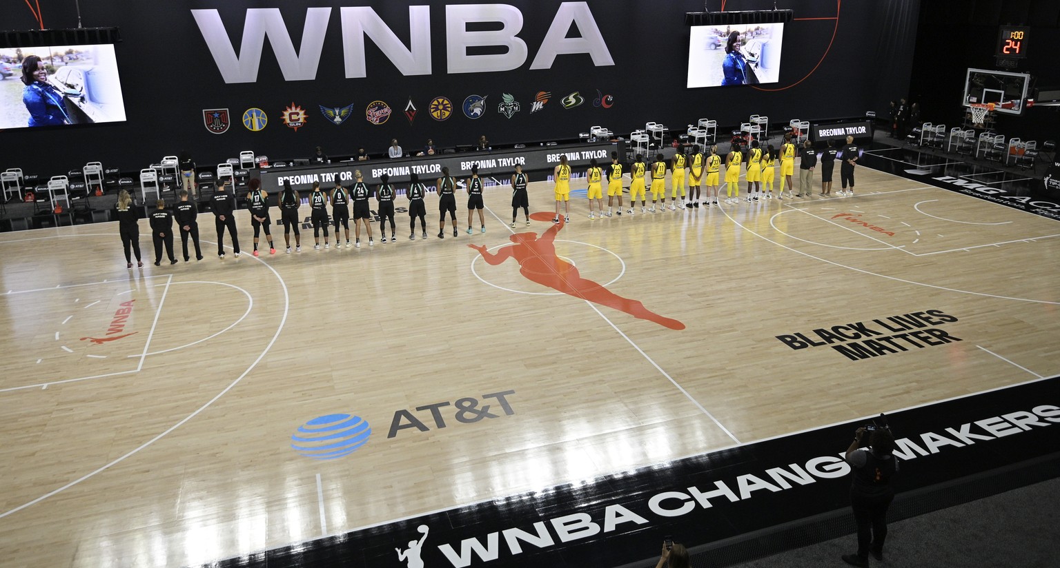 Members of the New York Liberty, left, and Seattle Storm observe a moment of silence in honor of Breonna Taylor before a WNBA basketball game, Saturday, July 25, 2020, in Ellenton, Fla. (AP Photo/Phel ...