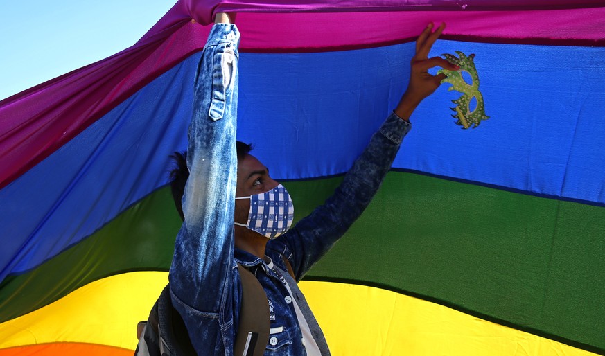 epa08906390 A participant holds up a rainbow-colored flag during the LGBT (Lesbian, Gay, Bisexual, and Transgender) pride march in Bangalore, India, 27 December 2020. Hundreds of LGBTQ people and thei ...