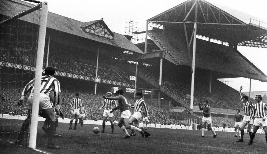 Football - 1969 / 1970 First Division - Everton 6 Stoke City 0 Everton s John Hurst and Stoke s Alan Bloor challenge for the ball at Goodison Park. The half-built Goodison Road Stand can be seen in th ...