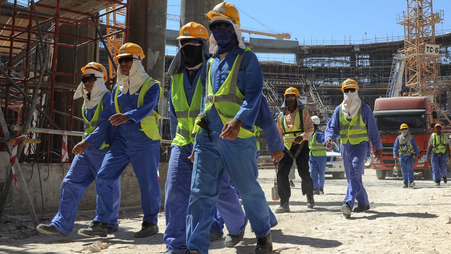 epa03956763 Foreign construction workers qleave a construction site in Doha, Qatar, 19 November 2013. The previous day, football&#039;s ruling body FIFA said it will continue to put pressure on 2022 W ...