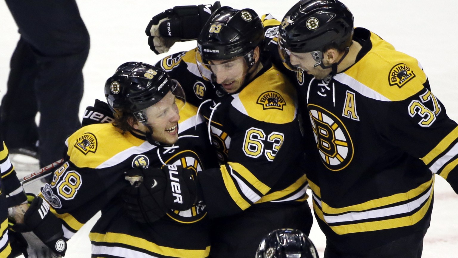 Boston Bruins right wing David Pastrnak (88) celebrates his goal with teammates left wing Brad Marchand (63) and center Patrice Bergeron (37) in the first period of an NHL hockey game against the San  ...