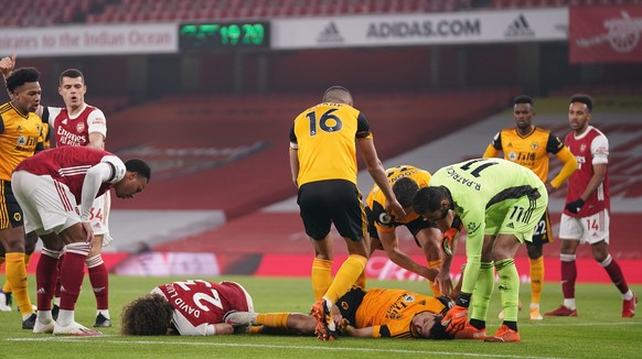 epa08851951 David Luiz of Arsenal (L) and Raul Jimenez of Wolverhampton (R) receive help after a head-on collision during the English Premier League soccer match between Arsenal FC and Wolverhampton W ...